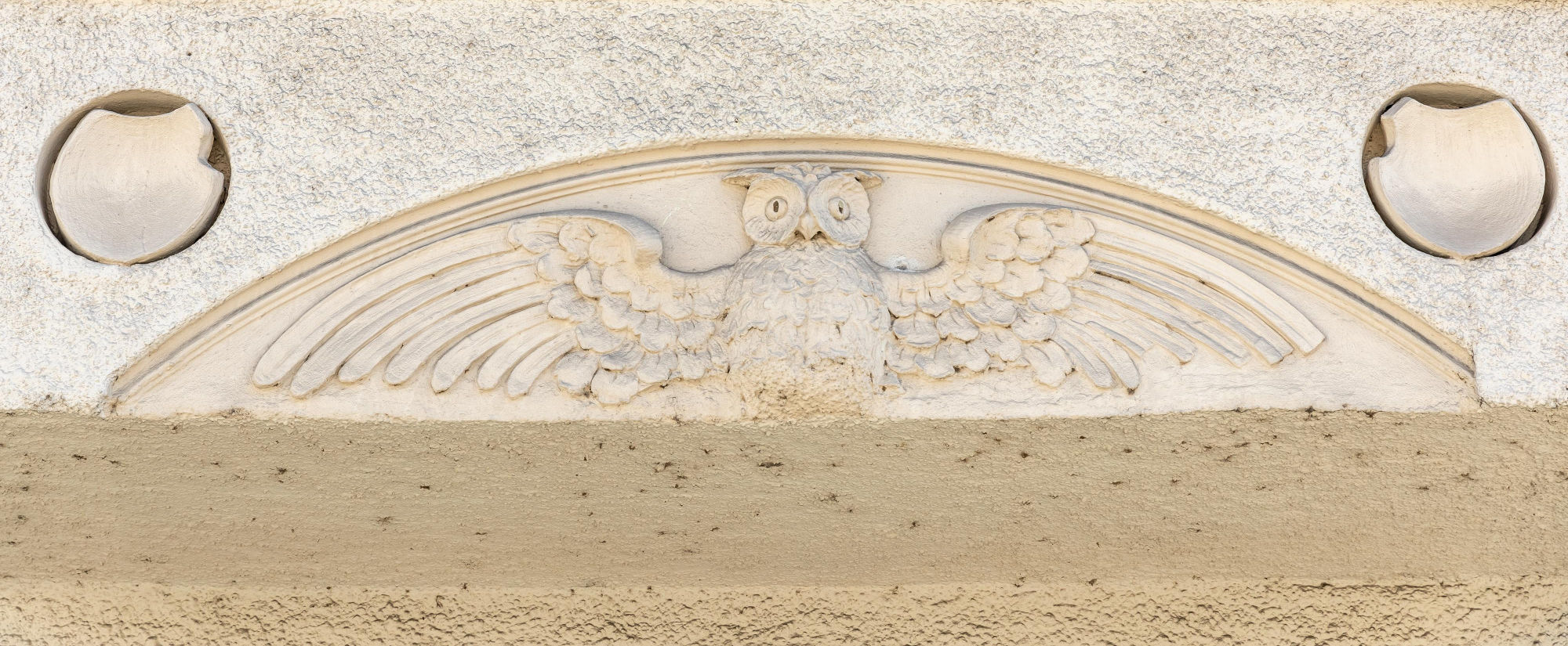 Eule mit gespreizten Flügeln - Verzierung an Münchner Hausfassade